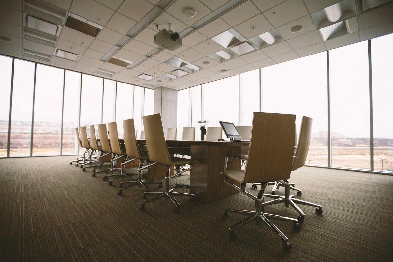 Salle du conseil vide avec une longue table de réunion
