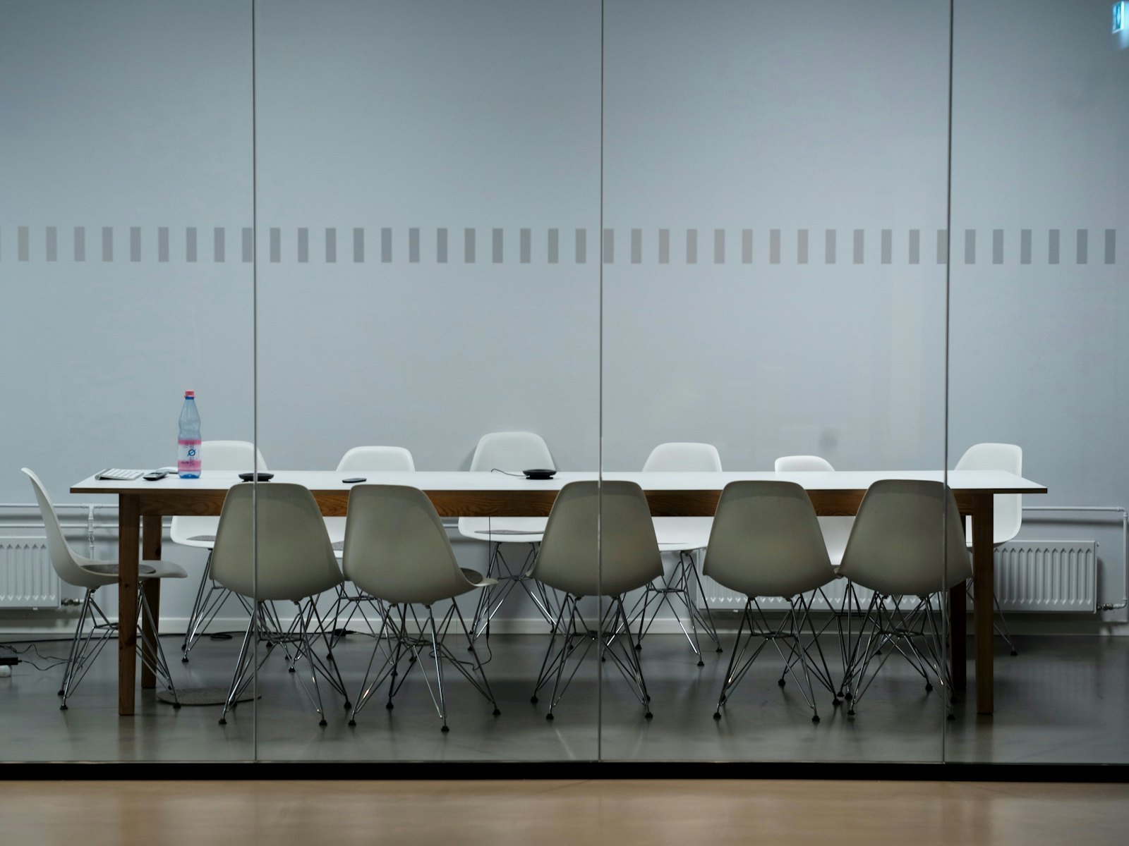Salle de réunion épurée avec une longue table blanche